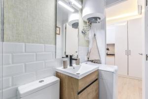 y baño con lavabo, aseo y espejo. en MyHouseSpain - Acogedor loft en pleno barrio de La Latina, en Madrid