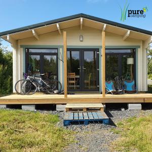 Une petite maison avec des vélos garés sur la terrasse couverte dans l'établissement Pure Space, à Kilkee