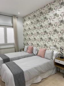 2 camas en una habitación con un mural en la pared en Exclusivo apartamento de diseño en PLAZA MAYOR VUT 09-449, en Burgos