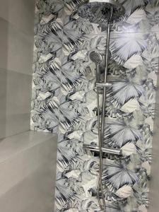 y baño con ducha y papel pintado con motivos florales. en Exclusivo apartamento de diseño en PLAZA MAYOR VUT 09-449, en Burgos
