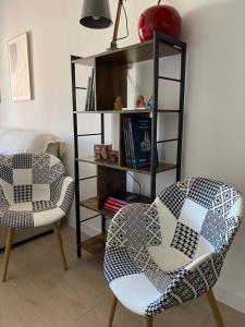 sala de estar con 2 sillas y estante para libros en Exclusivo apartamento de diseño en PLAZA MAYOR VUT 09-449, en Burgos