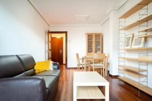 een woonkamer met een bank en een tafel bij MyHouseSpain - Fantastico piso cerca del centro in Oviedo