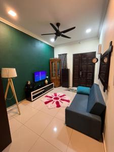 a living room with a couch and a ceiling fan at Dshomestay in Temerloh