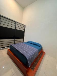 a bedroom with a bed with a blue blanket at Dshomestay in Temerloh +1 photo