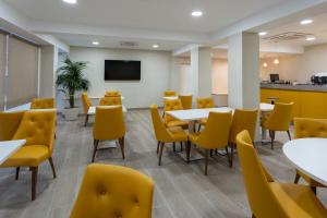 uma sala de jantar com mesas e cadeiras amarelas em Hotel SAIOLA em Camprodon