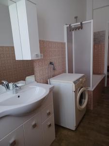 a bathroom with a sink and a washing machine at VRENI LODGE in Finale Ligure