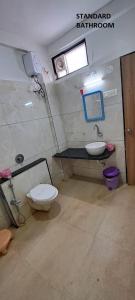 a bathroom with a toilet and a sink at Hotel Aaditya Palace in Bhusāwal