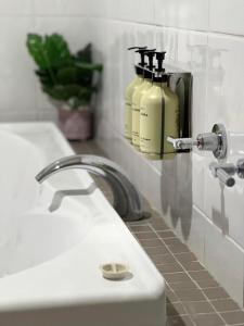 - un lavabo dans la salle de bains avec 2 bouteilles de savon liquide dans l'établissement Country Roads Motor Inn Dysart, à Dysart
