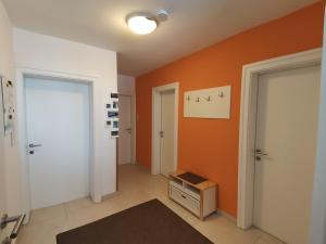 un pasillo con dos puertas y una pared de color naranja en Ferienwohnung Scheiber, en Sölden