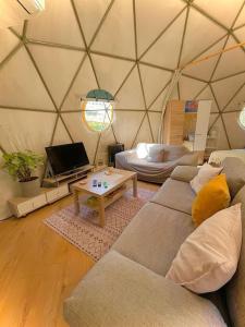 a living room with a couch and a table in a yurt at Dome in the Olive Grove כיפה גיאודזית ענקית ומודרנית בין עצי הזית in Yavneʼel