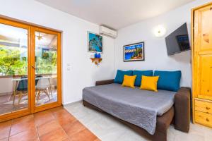 a bedroom with a bed with yellow and blue pillows at Apartments Jonke in Mandre