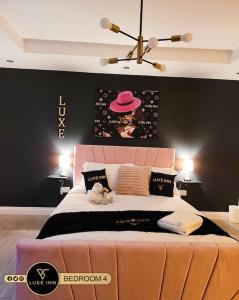 a bedroom with a large bed with a pink headboard at Luxury, 4 Bedroom House, FREE Parking, Borehamwood in Borehamwood