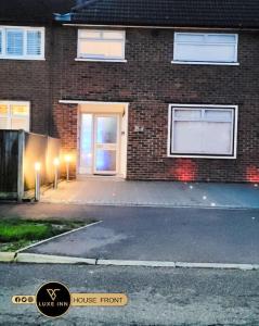 a brick house with a door and a driveway at Luxury, 4 Bedroom House, FREE Parking, Borehamwood in Borehamwood