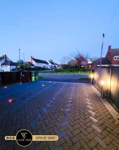 un estacionamiento con un camino de ladrillo con luces en Luxury, 4 Bedroom House, FREE Parking, Borehamwood, en Borehamwood