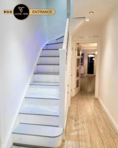 Una escalera con escaleras azules y blancas en una habitación en Luxury, 4 Bedroom House, FREE Parking, Borehamwood en Borehamwood