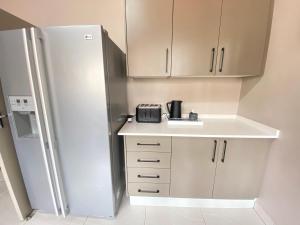 Una cocina con un refrigerador blanco y una encimera. en Oost Street, en Polokwane