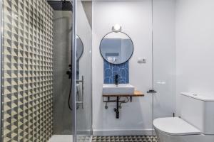 łazienka z prysznicem, umywalką i lustrem w obiekcie MyHouseSpain - Moderno apartamento ubicación inmejorable Madrid w Madrycie