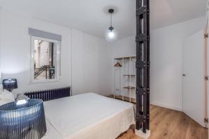 sypialnia z białym łóżkiem i oknem w obiekcie MyHouseSpain - Moderno apartamento ubicación inmejorable Madrid w Madrycie