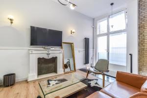 salon z kominkiem i telewizorem w obiekcie MyHouseSpain - Moderno apartamento ubicación inmejorable Madrid w Madrycie