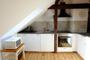 kuchnia z białymi szafkami i kuchenką mikrofalową w obiekcie heidel-home 2Raum Studio w mieście Heidelberg