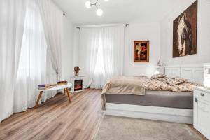 a white bedroom with a bed and a table at Romantická Chalupa Louka 