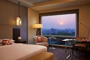 a hotel room with a bed and a large window at Hyatt Regency Ahmedabad in Ahmedabad