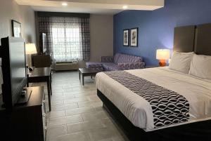 シャーツにあるLa Quinta Inn and Suites by Wyndham - Schertzのベッドとリビングルームが備わるホテルルームです。