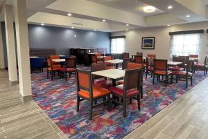 une salle à manger avec des tables et des chaises sur un tapis dans l'établissement La Quinta Inn and Suites by Wyndham - Schertz, à Schertz