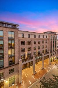 an apartment building with a sunset in the background at Cambria Hotel Savannah Downtown Historic District in Savannah