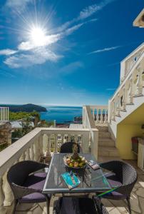 a balcony with a table and chairs with a view of the ocean at Amazing view apartment Slavica 3 in Dubrovnik