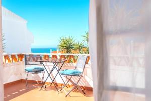 a balcony with two chairs and a table and the ocean at Ericeira Soulsurfers Guesthouse in Ericeira