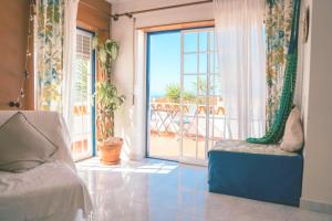 ein Wohnzimmer mit einer großen Glasschiebetür und einem Balkon in der Unterkunft Ericeira Soulsurfers Guesthouse in Ericeira