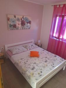 - un lit avec un oreiller orange dans la chambre dans l'établissement Apartment Dukic, à Sveti Filip i Jakov 92 autres photos