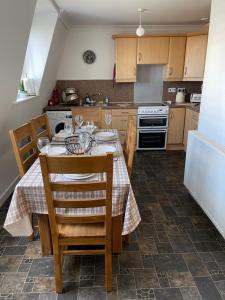 uma cozinha com uma mesa, cadeiras e um fogão em Yare Quays River View em Great Yarmouth