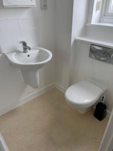 biała łazienka z toaletą i umywalką w obiekcie Yare Quays River View w mieście Great Yarmouth