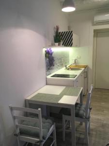 cocina con mesa, sillas y fregadero en Studio Apartment Sisi en Opatija