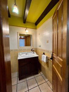 y baño con lavabo y espejo. en Apartamentos Turisticos Paseo de la Alameda, en Villaviciosa