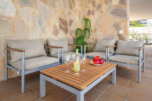 a table and chairs with wine glasses on a patio at Villa Marlenghi with Private Pool in San Bartolomé de Tirajana