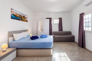 a bedroom with a blue bed and a couch at Villa Marlenghi with Private Pool in San Bartolomé de Tirajana