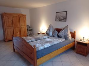 a bedroom with a wooden bed with two night stands at Kékház Vendégház in Écs