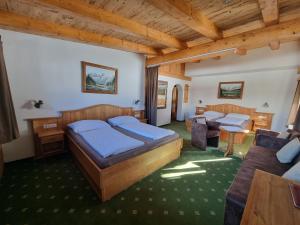1 dormitorio con 2 camas y sofá en Hotel Garni Zimmermann en Reith bei Kitzbühel