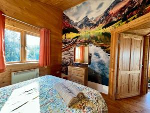a bedroom with a mountain mural on the wall at Reeds Lodge, Lake Pochard in South Cerney