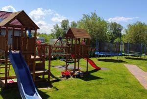 a playground with a slide and a swing set at Słoneczny Przystanek in Jarosławiec