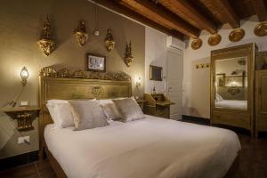 1 dormitorio con 1 cama blanca grande y espejo en Le Meraviglie di Alice, en Cagliari