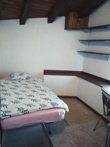 een kleine slaapkamer met een bed en een bureau bij '' Al Pèrgul '' in Civo