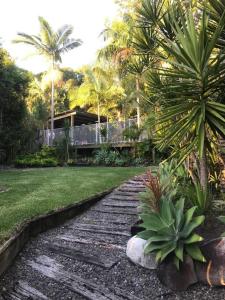 a walkway in a yard with palm trees and a house at Palm Springs Vibe - Gorgeous Large Home, Superb Location in Noosa Heads