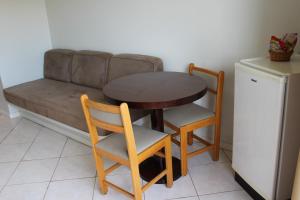 mesa pequeña, 2 sillas y sofá en Golden Suíte Hotel, en Campinas