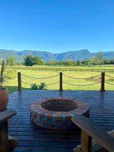 a brick fire pit on a wooden deck with two benches at Mirador da Montanha in Praia Grande