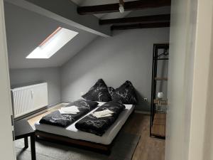 1 dormitorio con cama con sábanas y almohadas negras en Timeout24, en Bremen
