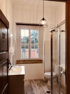 a bathroom with a toilet and a sink and a window at Thomar House in Tomar